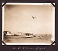 "83 C.T.S. in flight." Curtiss JN-4 aircraft number C747 on the ground and another (C864?) in the air, with hangar buildings in the background. (3573412031).jpg